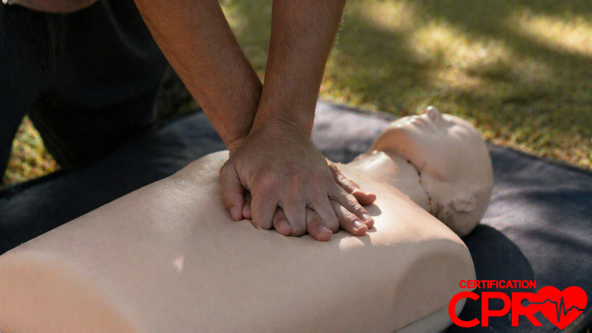 Person performing hands-only CPR on a mannequin outdoors in Nashville.
